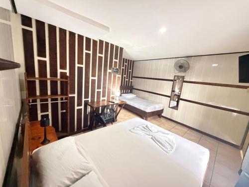 a room with two beds and a bench in it at Hotel Don Roberto in San Isidro de El General