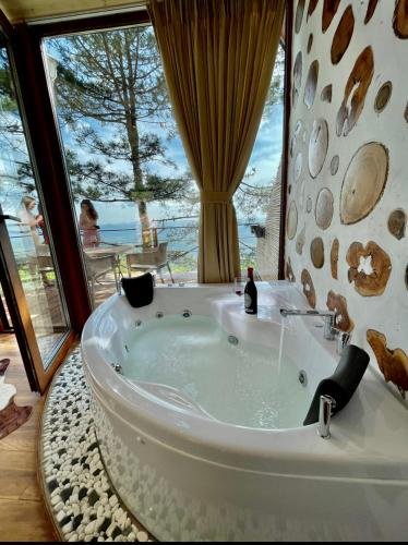 a bath tub in a room with a large window at Dajti Alpin Villas in Tirana
