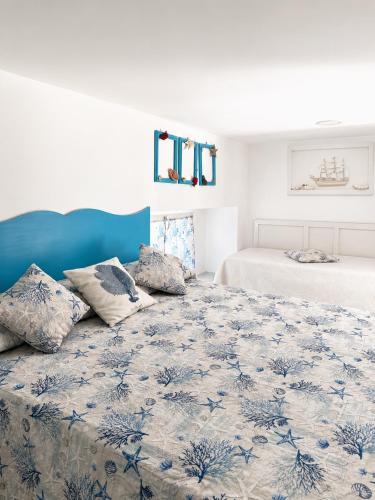 a bedroom with two beds and a blue and white bedspread at La Bella Annacapri in Anacapri