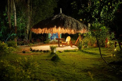 a hut with a table and a chair in a yard at EcoHotel Inka Minka in Santa Marta