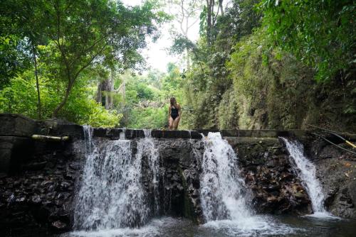 a woman standing on top of a waterfall at EcoHotel Inka Minka in Santa Marta