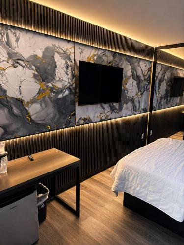 a bedroom with a bed and a flat screen tv at The Vine Hotel Bronx New in Bronx