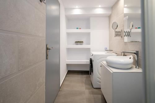 a white bathroom with a sink and a toilet at Milva Apartments in Kos