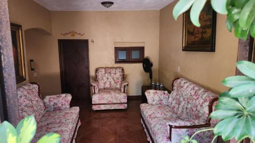 a living room with two chairs and a couch at Posada Las Reynas in Mineral de Pozos