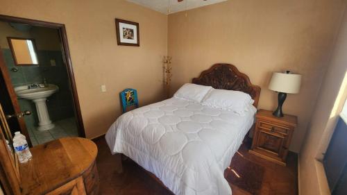 a bedroom with a bed and a bathroom with a sink at Posada Las Reynas in Mineral de Pozos