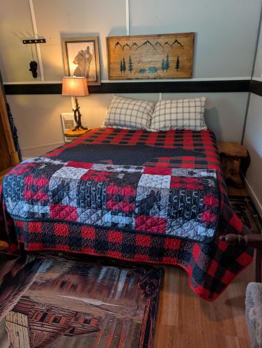 a bedroom with a bed with a quilt on it at Magnolia Cottage Bigfoot Hideaway in Hope
