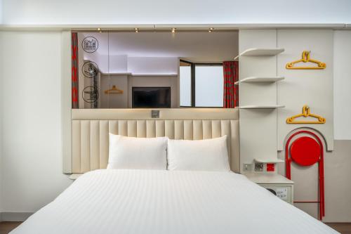a bedroom with a white bed and a red chair at Point A Hotel Glasgow in Glasgow