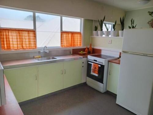 a kitchen with a white refrigerator and a sink at Club Retro in Hawera