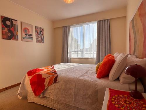 a bedroom with a large bed with a window at Club Retro in Hawera