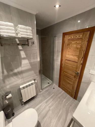 a bathroom with a toilet and a sink and a mirror at Casa da Xastra in Vimianzo
