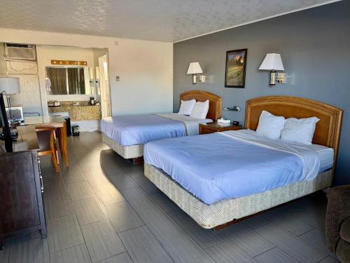 a hotel room with two beds and a kitchen at Bristlecone Motel in Ely
