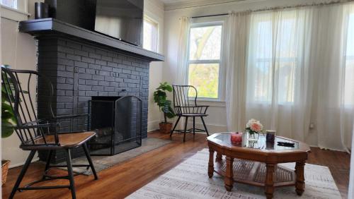 a living room with a fireplace and a table and chairs at This Old House in Detroit