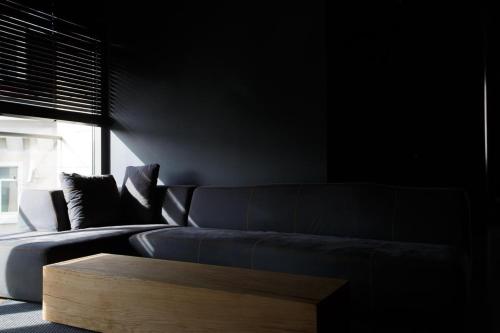 a living room with a couch and a wooden coffee table at CrownPlaza Boutique & Central in Chişinău