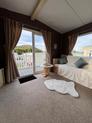 a bedroom with two beds and a large window at Welsh Bay Hideaway 2 bed caravan with sun deck in Aberystwyth
