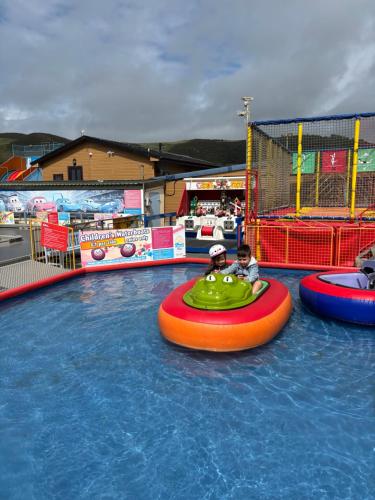 a couple of people riding on an inflatable raft in the water at Welsh Bay Hideaway 2 bed caravan with sun deck in Aberystwyth