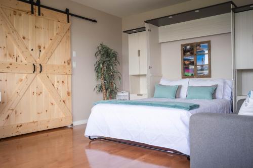 a bedroom with a bed and a sliding barn door at Panoramic Acres B & B - Lake & Mountain Views in Vernon