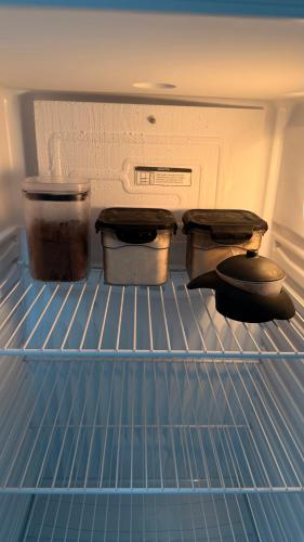 two pots and pans are sitting in an open refrigerator at Aracaju Apartamento 2 Quartos Proximo A Orla de Atalaia Praia de Aruana Aeroporto Shopping Sul in Aracaju