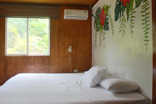 a bed with two pillows in a room with a window at Cabañas Ismasoris in Providencia