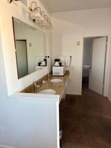 a bathroom with a sink and a mirror at Bristlecone Motel in Ely