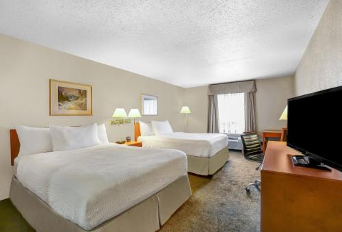 a hotel room with two beds and a flat screen tv at Prairie Crest Red Deer by IHG in Red Deer