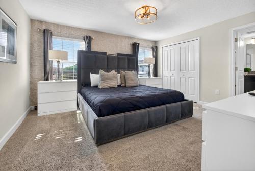 a bedroom with a large black bed in a room at 1556 PD - Poolside Bliss: Enchanted 4BR Townhome in Davenport
