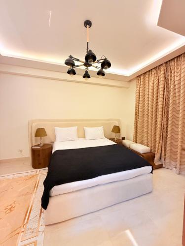 a bedroom with a large bed and a chandelier at Sharm Hills Elite Suite in Sharm El Sheikh