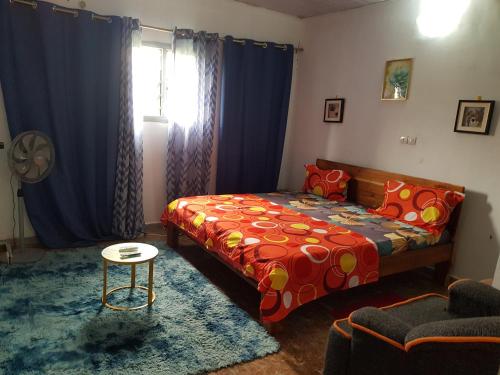 a bedroom with a bed and a table at Résidence BEDEL in Yamoussoukro