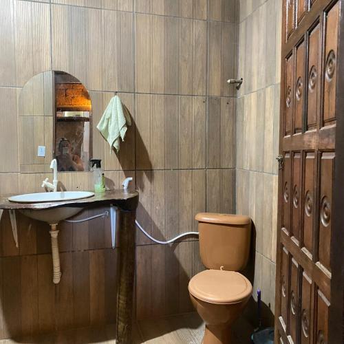 a bathroom with a toilet and a sink at Sítio com suítes e áreas de Lazer in Palmeiras