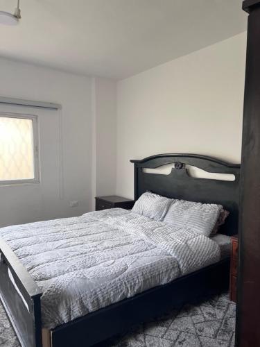 a bedroom with a bed with a wooden frame and a window at Saeeds apartment in Ajloun