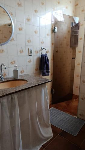 a bathroom with a shower with a sink and a mirror at Casa Pé na Areia Cantão do Bora Bora - Manaaki Surf Hostel in São Sebastião