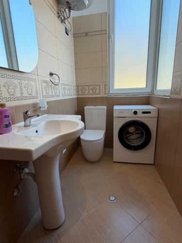 a bathroom with a sink and a washing machine at Owen Rooftop in Shëngjin