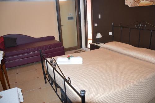 a bedroom with two beds and a couch at Il Quadrifoglio in Trapani