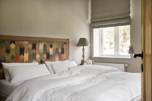 two white beds in a bedroom with a window at Leuchtturnwohnung in Pommerby