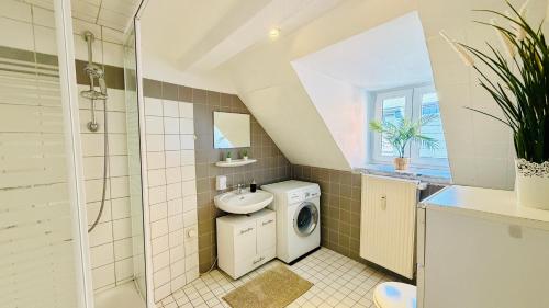 a bathroom with a sink and a washing machine at FewoZauber "Pension am Dom", Historische Apartments, Superzentral, 7min zum Schloss in Schwerin