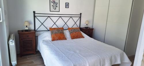 a bedroom with a white bed with two pillows at Adosado en Casco Antiguo con piscina in Altea