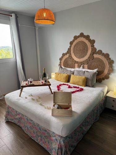 a bedroom with a large bed with a table on it at Résidence Terre et Passion in Ducos