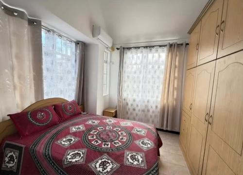 a bedroom with a red bed and a window at Muikora Albion in Albion