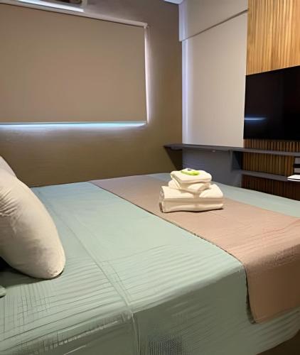a hotel room with a bed with a towel on it at Apartamento - Leblon 409 Conforto & Estilo. in Cuiabá