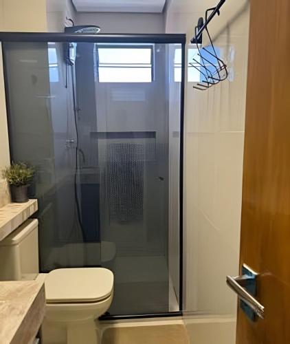a glass shower in a bathroom with a toilet at Apartamento - Leblon 409 Conforto & Estilo. in Cuiabá