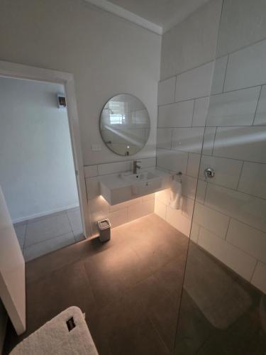 a bathroom with a shower and a sink and a mirror at Savusavu Terraces - Unit 2 in Savusavu