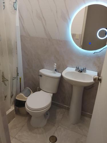 a bathroom with a toilet and a sink and a mirror at departamento familiar privado trujillo huanchaco in Huanchaco