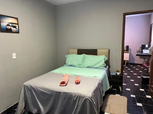 two pair of pink slippers sitting on a bed at Villa Serena in Castanhal