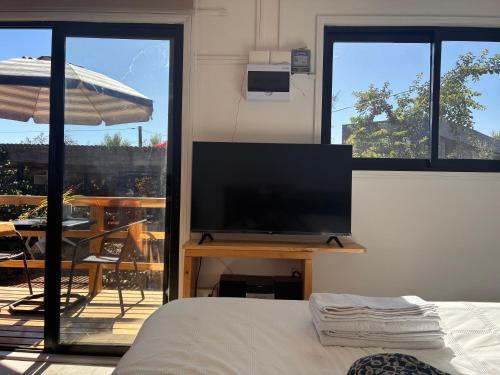 a bedroom with a flat screen tv on a table at La Ola Tiny House in Maitencillo
