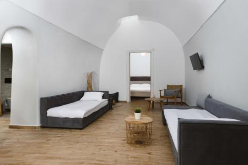 a living room with two couches and a table at Amaryllis Suites Santorini in Fira