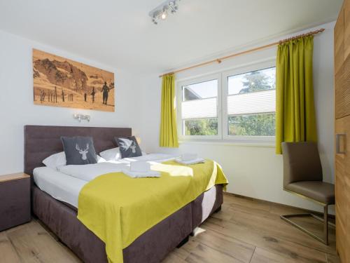 a bedroom with a large bed and a chair at Sonnen Lodge Kaprun in Piesendorf