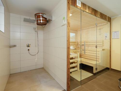 a shower with a glass door in a bathroom at Sonnen Lodge Kaprun in Piesendorf