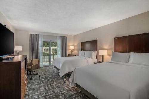 a hotel room with two beds and a flat screen tv at Crowne Plaza San Diego - Mission Valley by IHG in San Diego