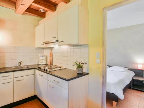 a kitchen with white cabinets and a bed in a room at Lac Bleu nr 10 in Lacapelle-Marival