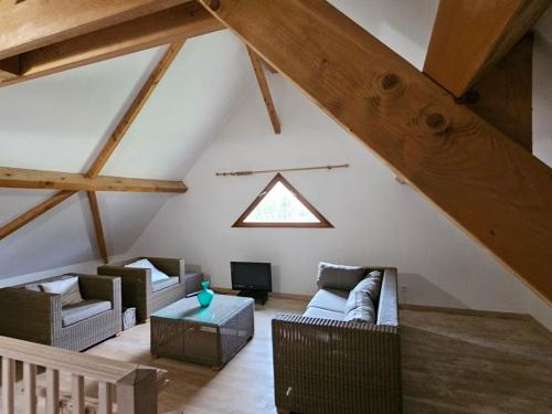 an attic living room with couches and a window at Lac Bleu nr 10 in Lacapelle-Marival
