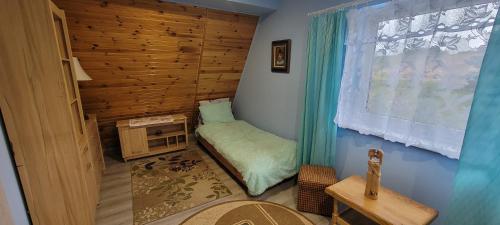 a small room with a bed and a window at Duchniczowe in Prusie